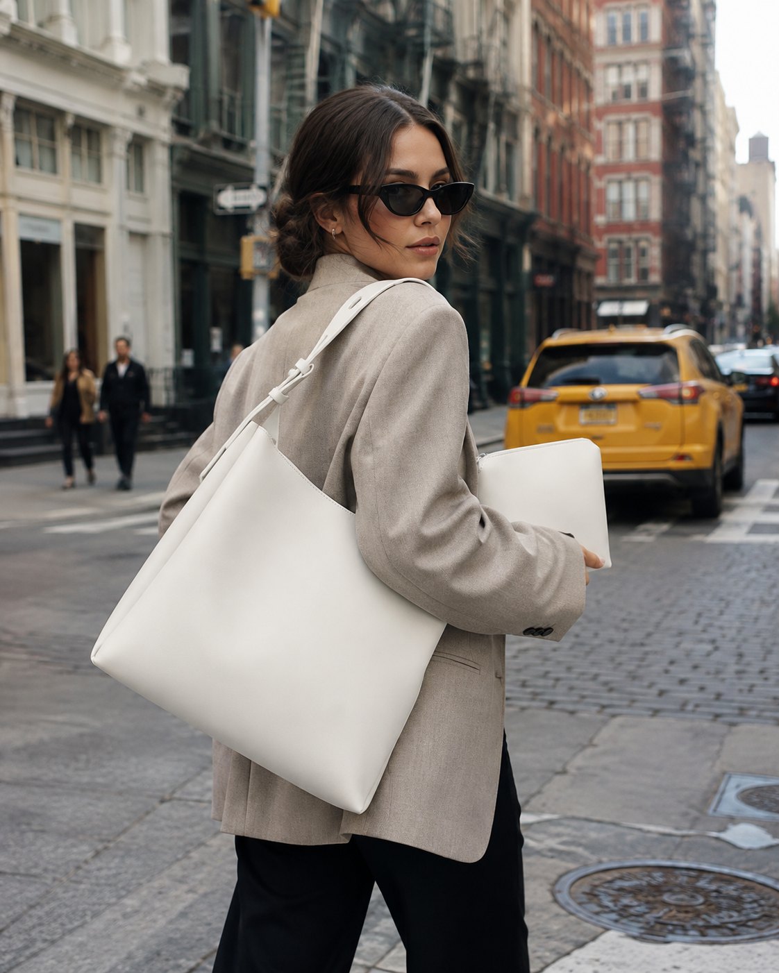 The Avnelle Atelier Tote in cream, carried through the city